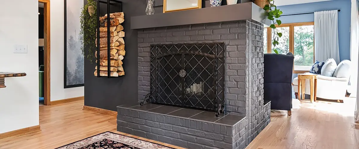 Modern black brick fireplace in a stylish living room with hardwood floors and cozy seating area