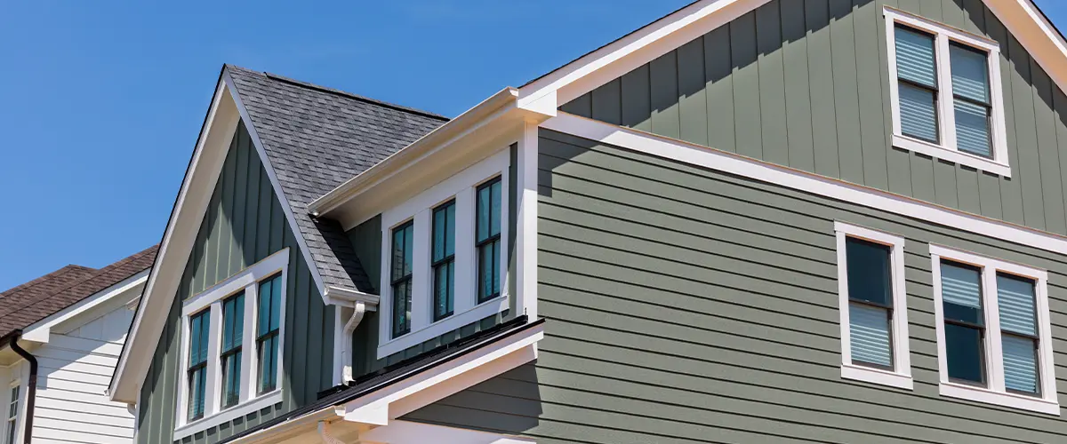 Modern home exterior with green board and batten siding and white trim, enhancing curb appeal and energy efficiency.