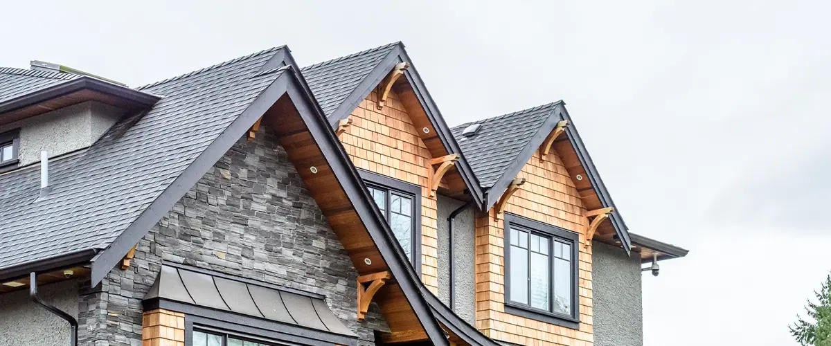 Modern home with architectural shingles, stone veneer, and wood siding, showcasing high-end exterior design and roofing.